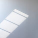Eine weiße Wand mit dem Schattenspiel eines Fensters